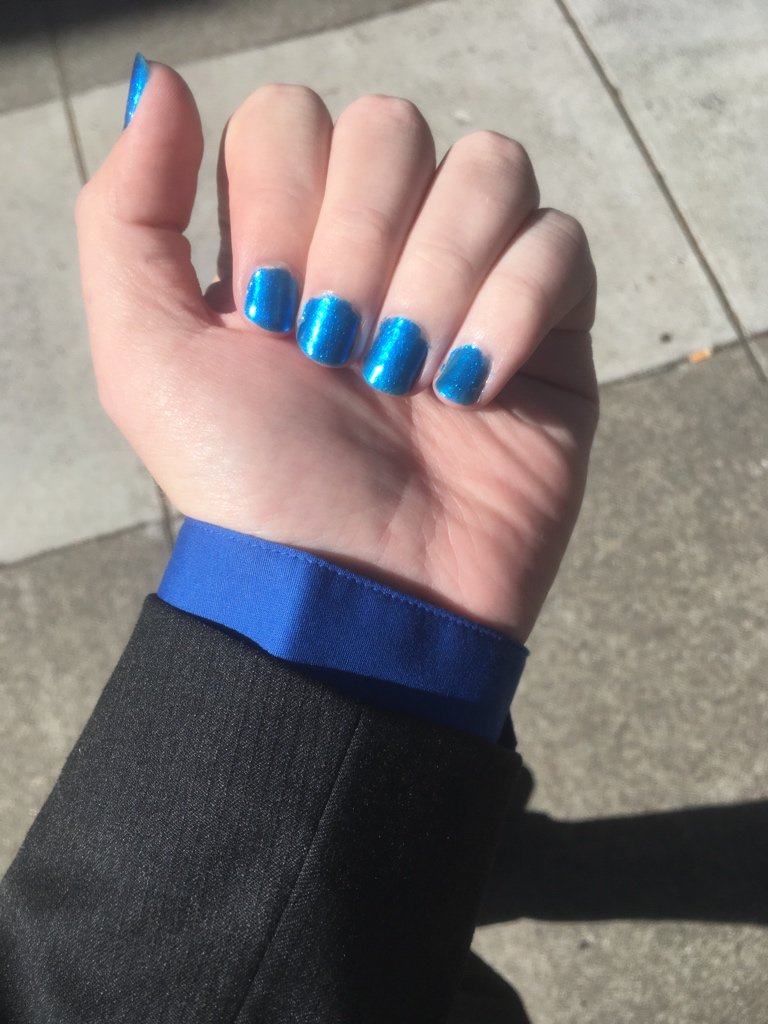 OPI “Do You Sea What I Sea”, while also wearing a blue dress shirt under a black suit jacket.